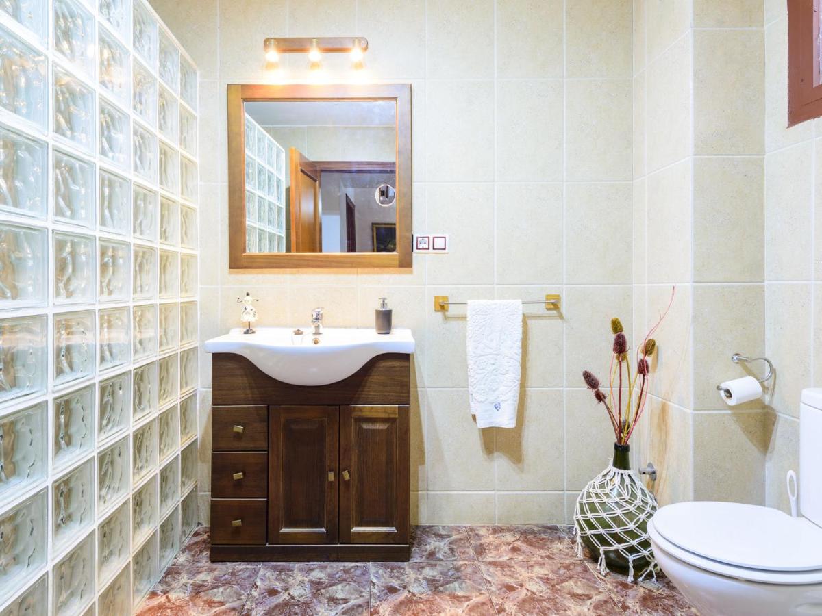 Baño con lavabo de madera y pared de vidrio