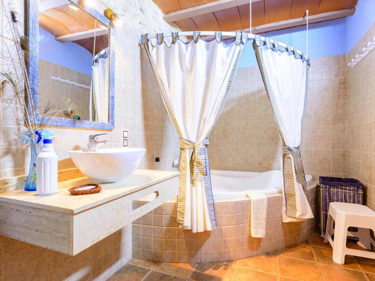 Baño completo con pared de piedra y bañera