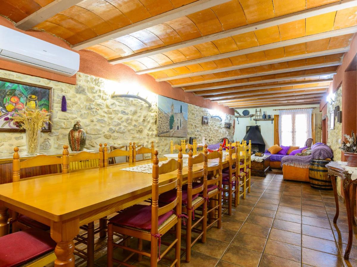 Gran salón-comedor con chimenea y paredes de piedra — Casa Rural Calaceit
