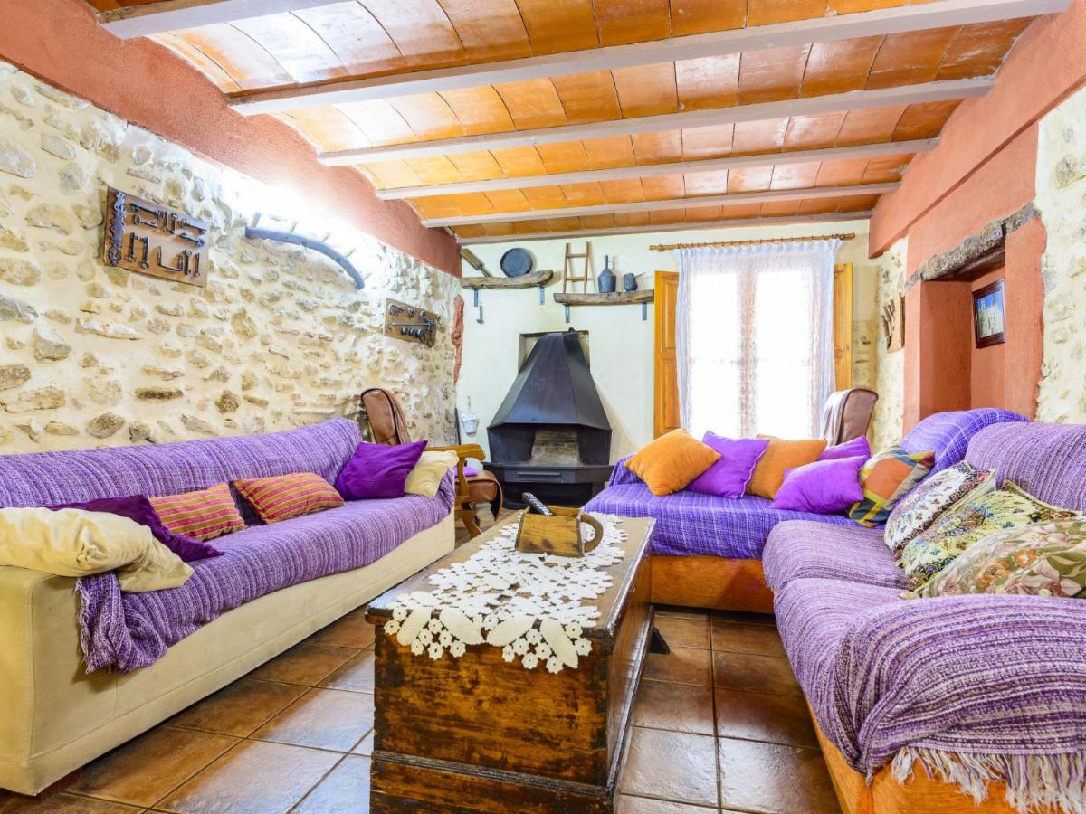 Salón con sofás, chimenea y pared de piedra